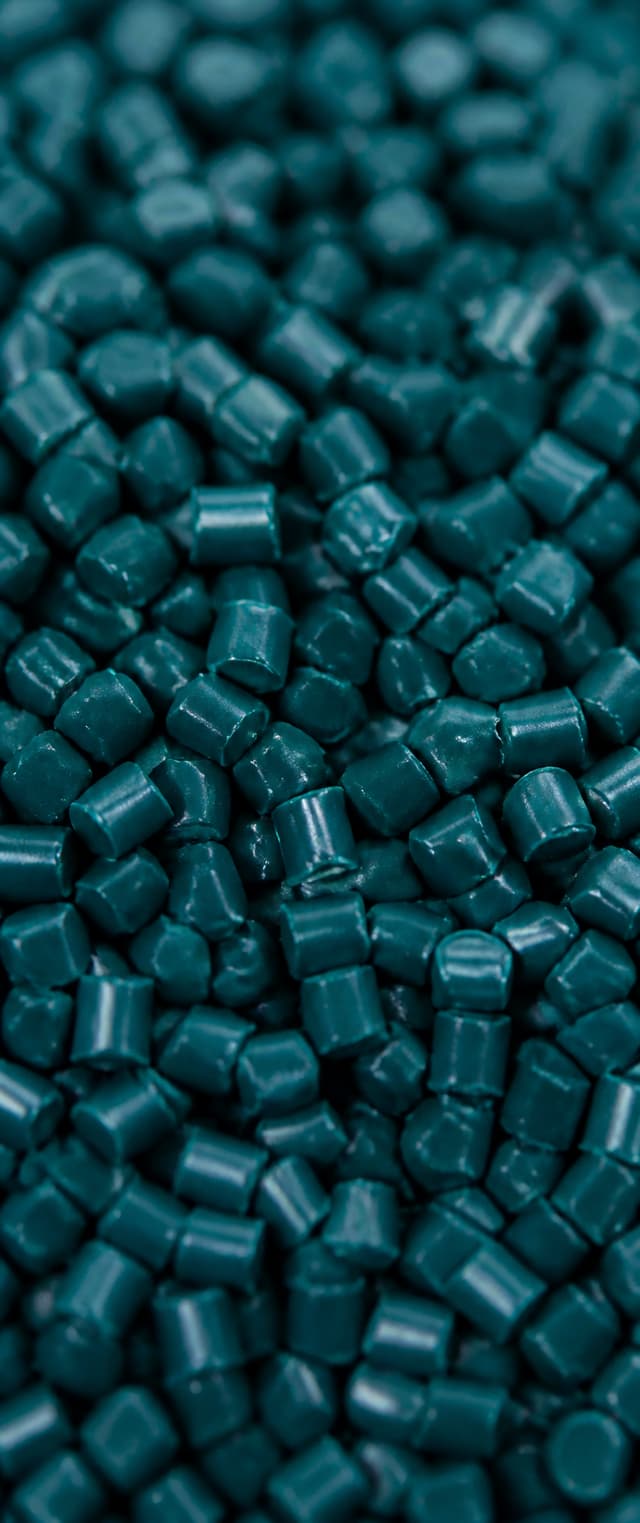 Close view of deep teal polymer granules